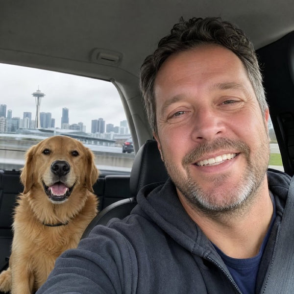 David K. in the car with Duke, his Golden Retriever in a black CollarZen collar and their dog wearing CollarZen